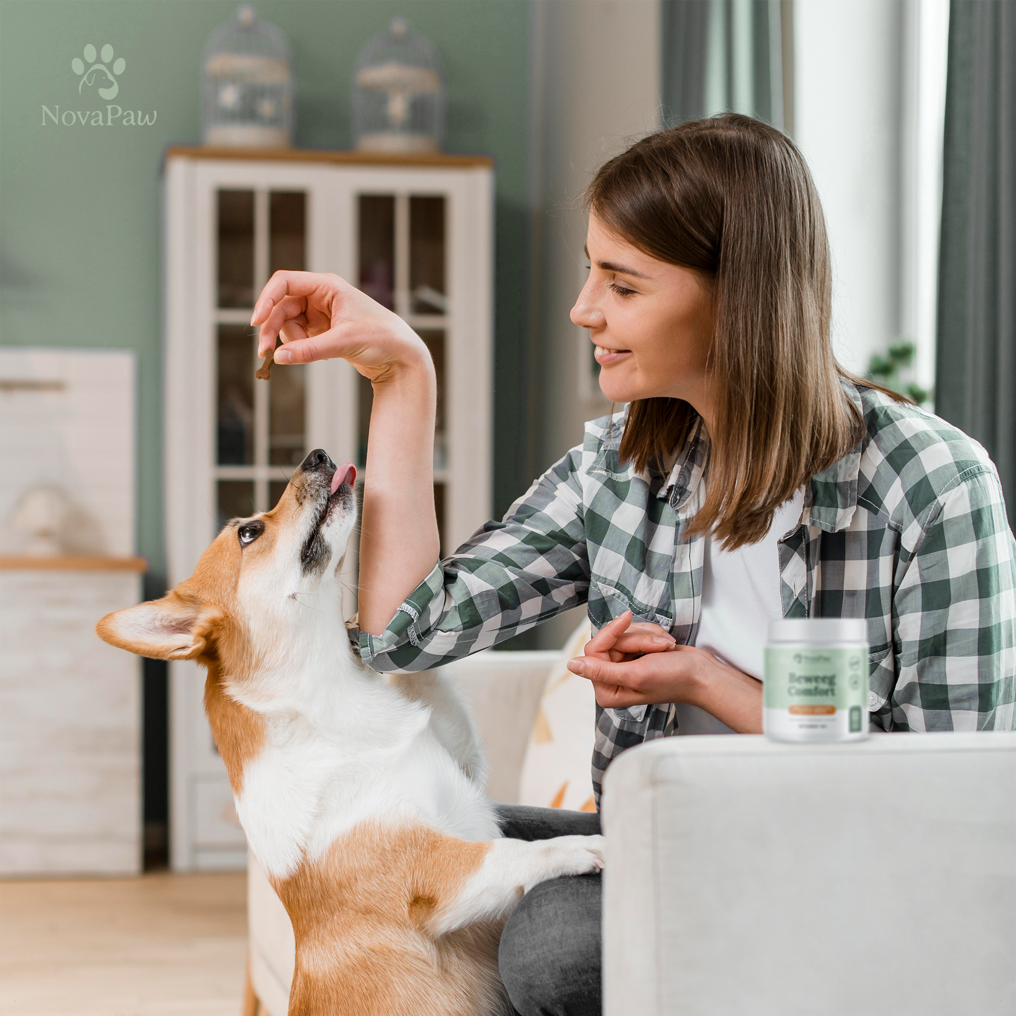 Vrouw geeft haar hond een NovaPaw Beweeg Comfort snack in een warme huiselijke setting.
